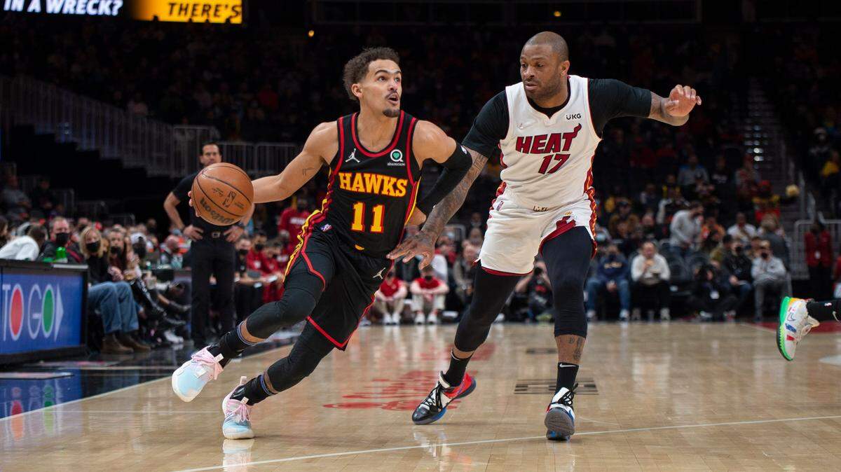 El armador de los Atlanta Hawks, Trae Young (11), trata de evadir al delantero del Miami Heat, P.J. Tucker (17), durante la primera mitad de un partido de la NBA el viernes, 21 de enero de 2022, en Atlanta.