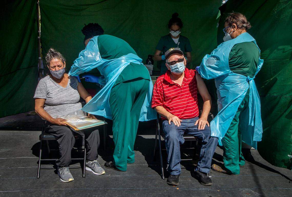University of Miami health personnel vaccinate a couple against COVID-19 during a Farmworker Health Fair held at the Florida Farm Workers Association in Homestead, on Saturday, March 27, 2021.