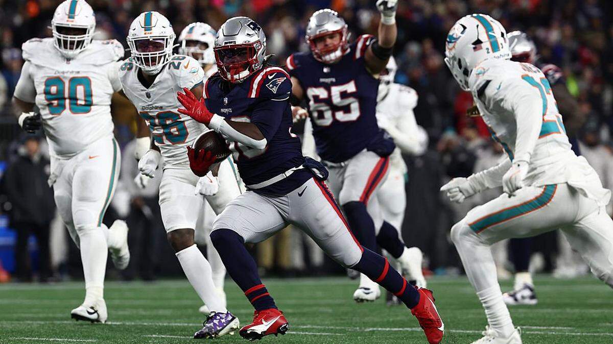El jugador de los Patriots Rhamondre Stevenson (#38) corre con el ovoide en el partido ante los Dolphins de Miami, celebrado el 4 de enero de 2026 en Miami.