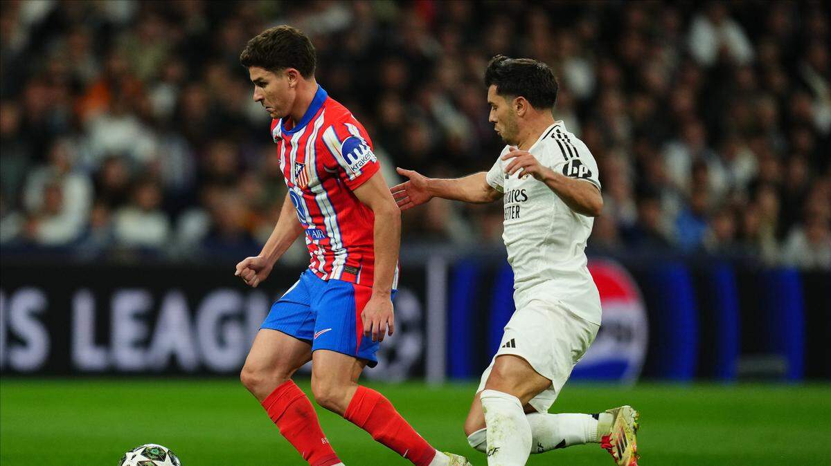 El delantero del Atlético Julian Álvarez (izq.) conduce el balón ante la marca de Brahim Díaz, del Real Madrid, en el partido de ida de los octavos de final de la Liga de Campeones, celebrado el 5 de marzo de 2025 en el estadio Santiago Bernabéu de la capital española.