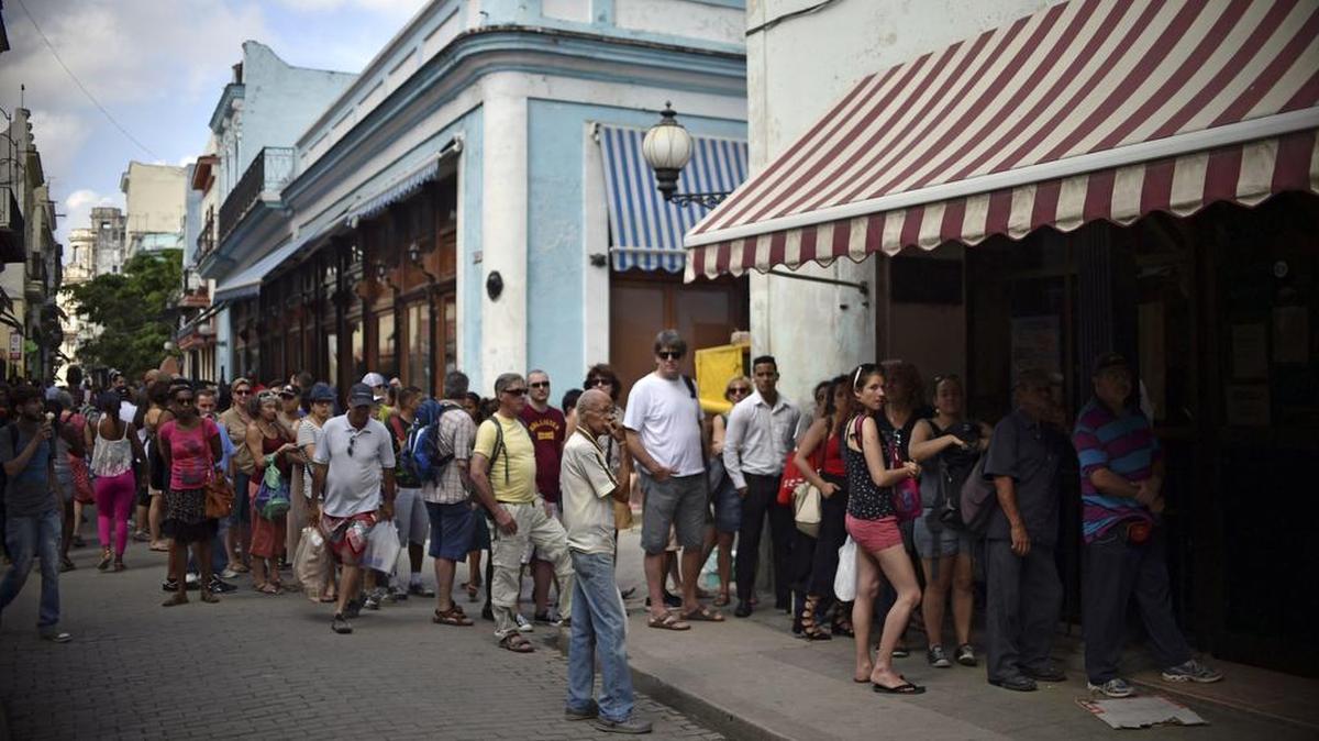 Foto de archivo del 19 de marzo de 2016 muestra a cubanos y turistas haciendo fila afuera de una oficina de Western Union en La Habana, Cuba.