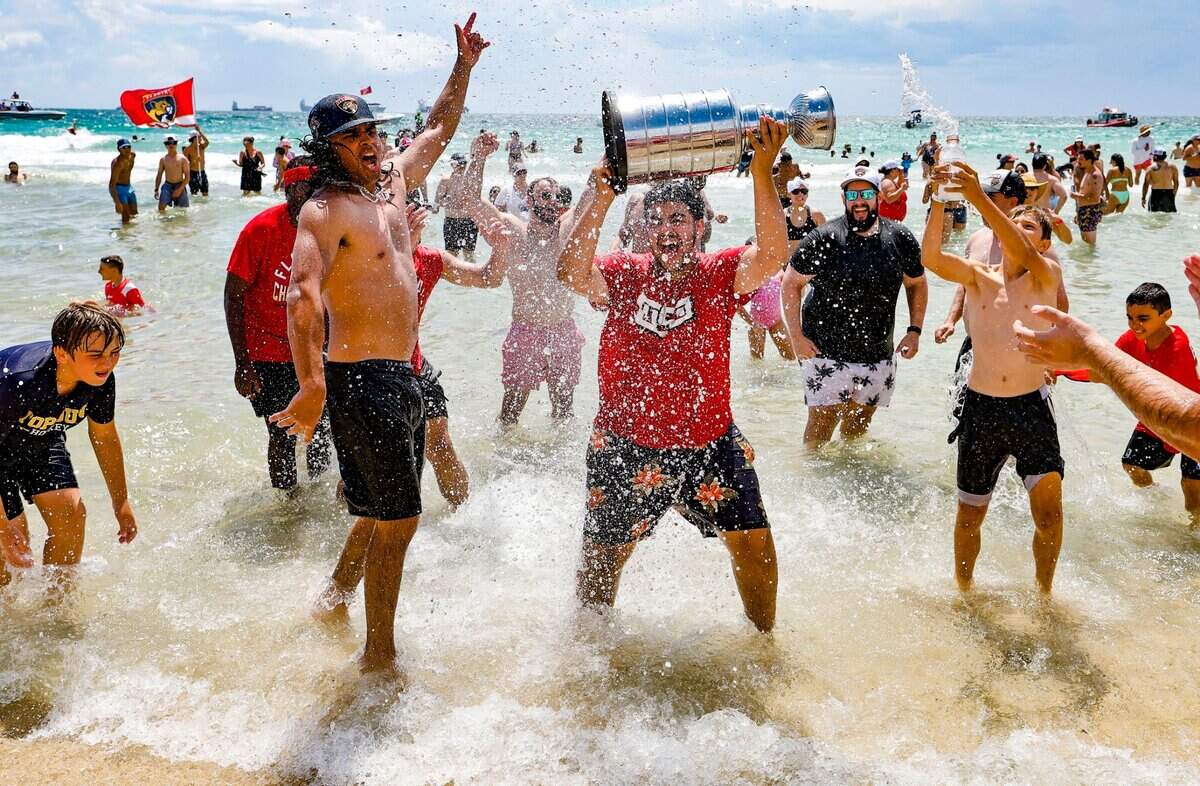 Aficionados de los Panthers levantan una réplica del trofeo de la Copa Stanley durante el desfile por la segundo título consecutivo de la NHL conseguido por el equipo, el domingo 22 de junio de 2025 en Fort Lauderdale, Florida.