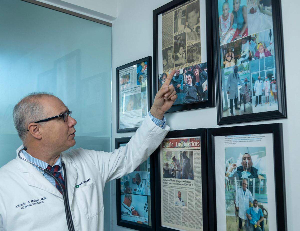 El doctor Alfredo Melgar muestra fotos de algunos de los activistas cubanos que ha atendido en su clínica.