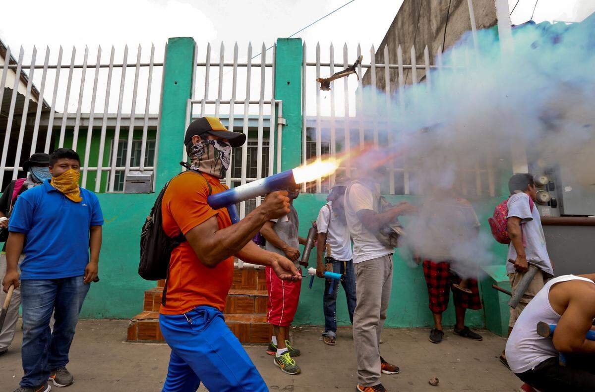 Un manifestante enmascarado dispara un motero casero en el barrio de Monimbo durante las violentas protestas en Masaya el 2 de junio del 2018. (AP Photo/Esteban Felix)