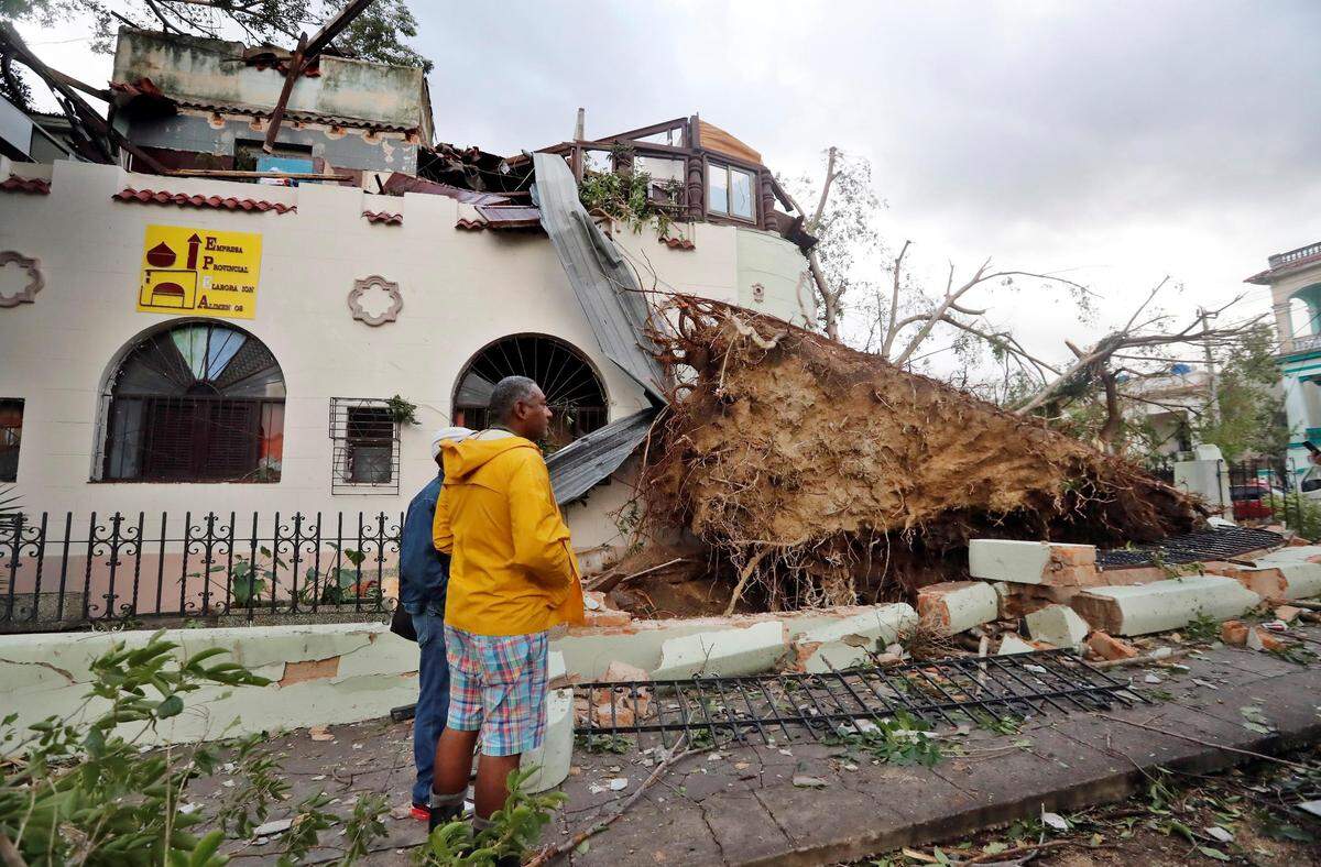 Vecinos observan los daños causados a una vivienda tras el paso de un tornado, este lunes, en La Habana.