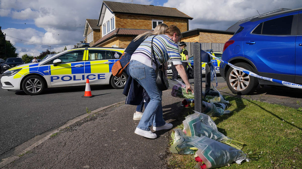 Dos personas dejan flores cerca del lugar donde fueron asesinadas la esposa y dos hijas de John Hunt, un locutor deportivo de la BBC, en Bushey, Reino Unido, el miércoles 10 de julio de 2024. 
