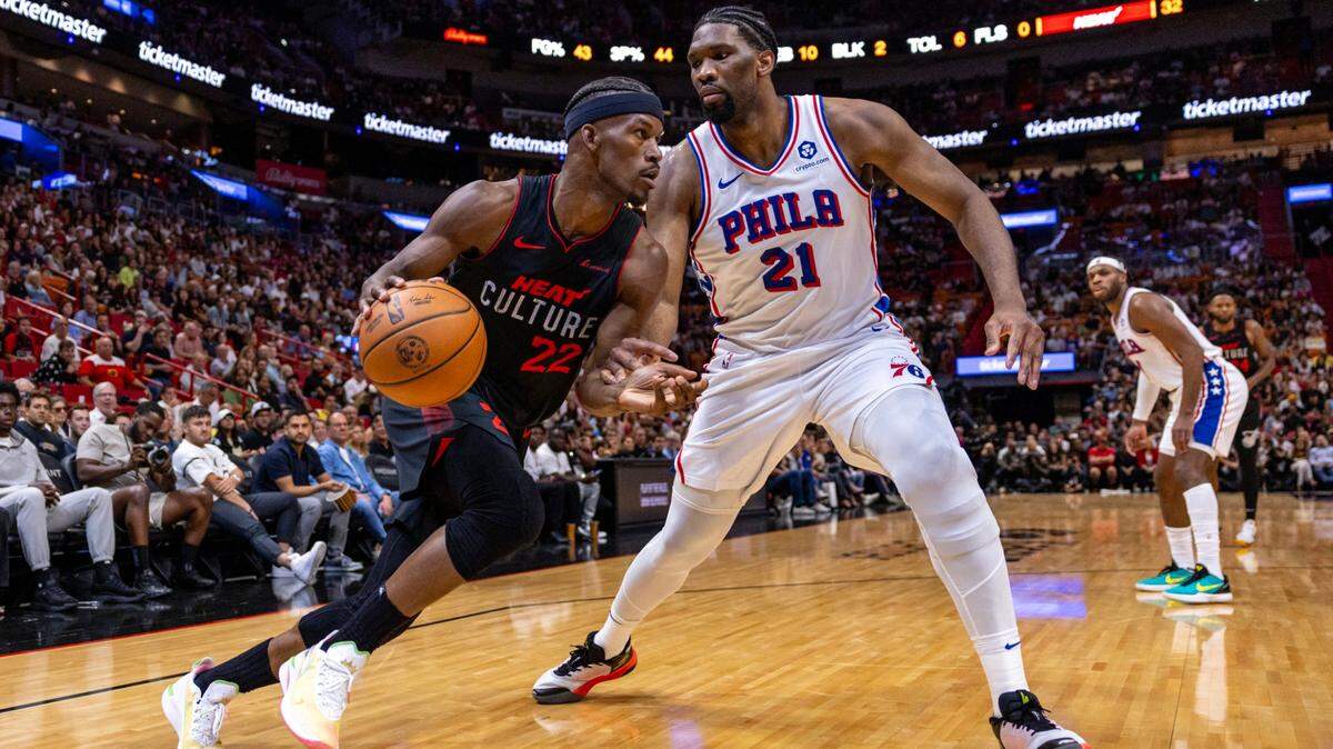 El jugador del Heat Jimmy Butler (izq.) trata de pasar la marca de Joel Embiid, de los 76ers de Filadelfia, en el partido celebrado el 4 de abril de 2024 en Miami.