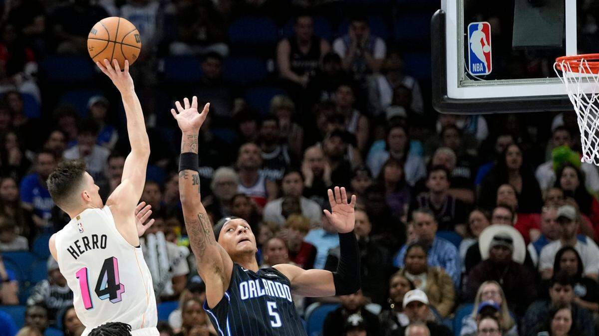 Tyler Herro (14) del Miami Heat hace un tiro sobre Paolo Banchero (5) del Orlando Magic durante el tiempo extra de un partido de baloncesto de la NBA, el sábado 11 de febrero de 2023 en Orlando, Florida (AP Photo/John Raoux)