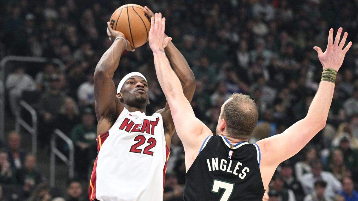 El jugador del Heat Jimmy Butler (izq.) tira al aro ante la marca de Joe Ingles, de los Bucks de Milwaukee, en el partido celebrado el 16 de abril de 2023 en el Fiserv Forum de Milwaukee.