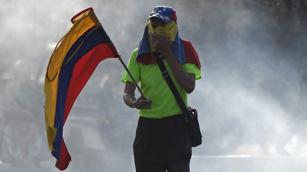 Un manifestante de la oposición sostiene una bandera venezolana después de que miembros de la Guardia Nacional Bolivariana se unieran al presidente interino Juan Guaidó la mañana del martes.