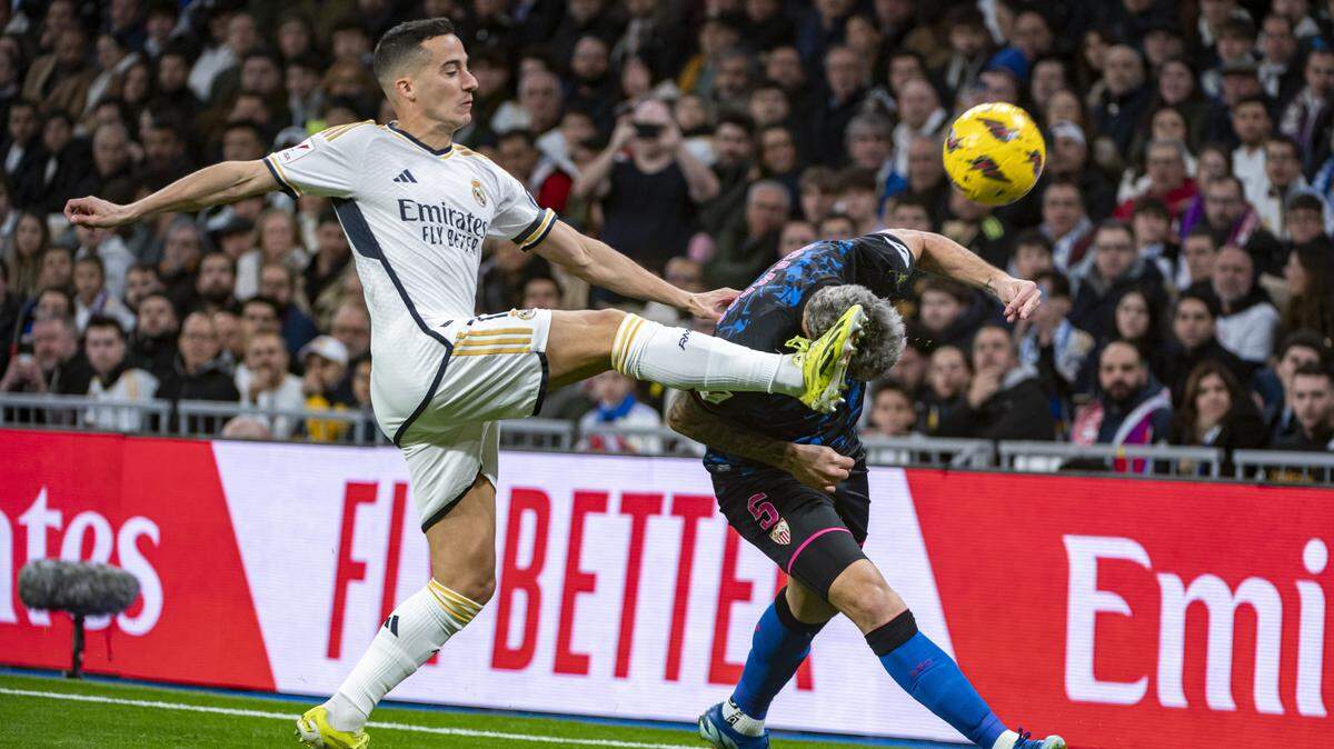 El jugador del Real Madrid Lucas Vásquez lucha por la pelota con Lucas Ocampos, de Sevilla, en el partido de la liga española celebrado el domingo 25 de febrero de 2024 en el estadio Santiago Bernabéu.
