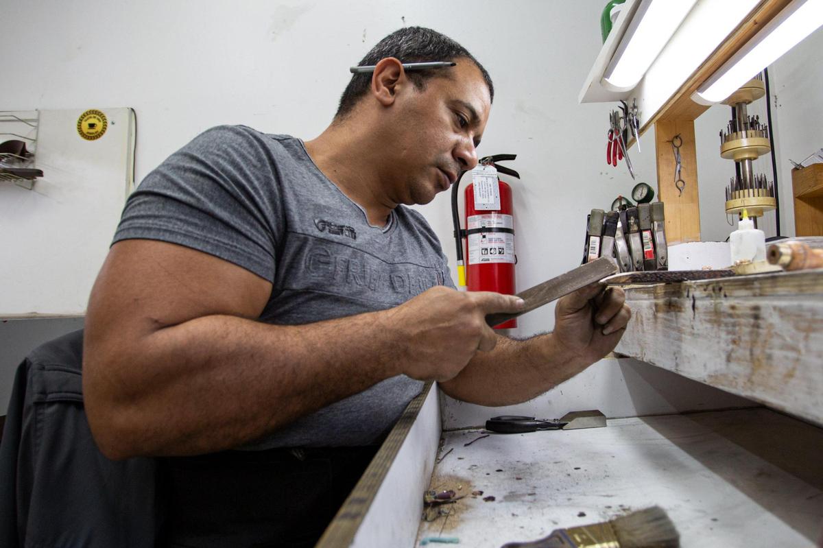 Janner Béez trabaja en una pieza de metal en la joyería Tazita de Oro, en Westchester, el 18 de diciembre.