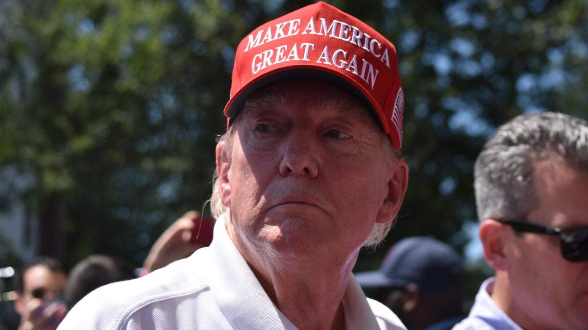 El ex presidente de los Estados Unidos, Donald J. Trump, firma gorras y revistas de sus seguidores.