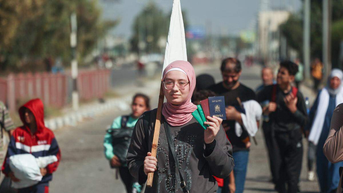 Una mujer palestina muestra su pasaporte e identificación mientras abandona la Ciudad de Gaza y se dirige hacia el sur de la Franja con decenas de personas más, el martes 7 de noviembre de 2023.