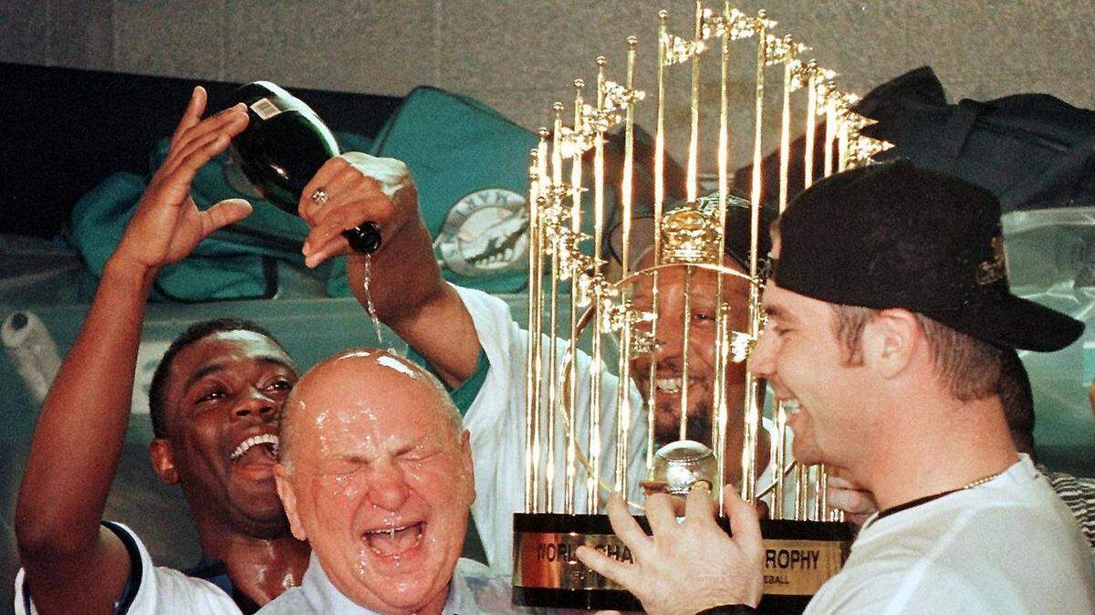 Los jugadores de los Marlins Edgar Rentería, Gary Sheffield y Tony Saunders (de izq. a der.) celebran con el dueño del equipo Wayne Huizenga el título de la Serie Mundial el 26 de octubre de 1997.