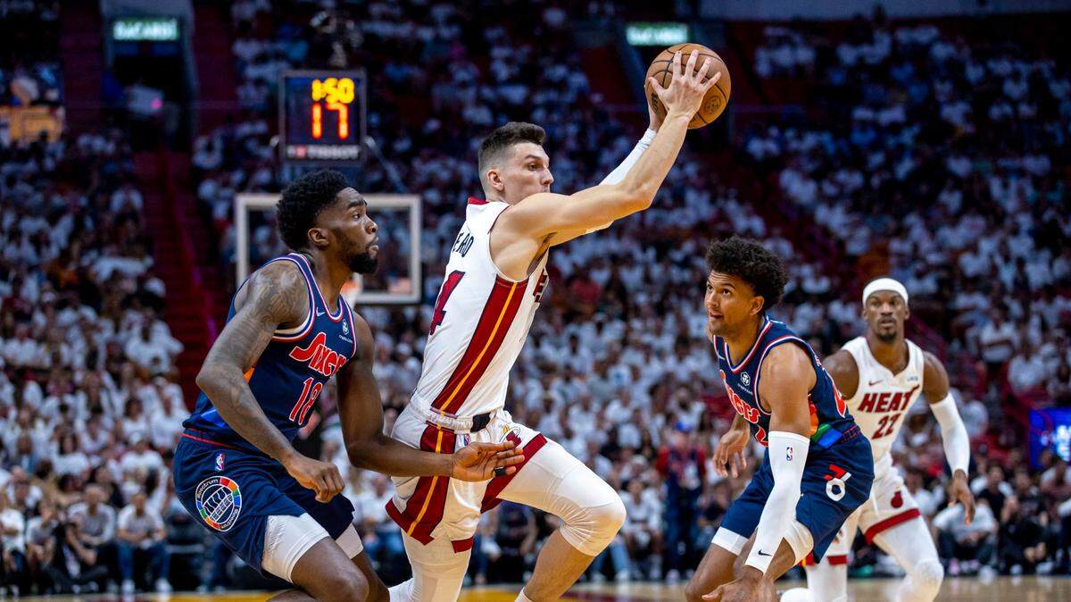 El jugador del Heat Tyler Herro (centro) entra al aro ante la marca de Paul Millsap, de los 76ers de Filadelfia, en el partido inicial de la serie de segunda ronda de los playoffs de la NBA, celebrado el 2 de mayo de 2022 en Miami.