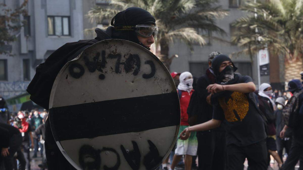 Manifestantes y policías antimotines se enfrentan el lunes 25 de noviembre de 2019, en Santiago de Chile.