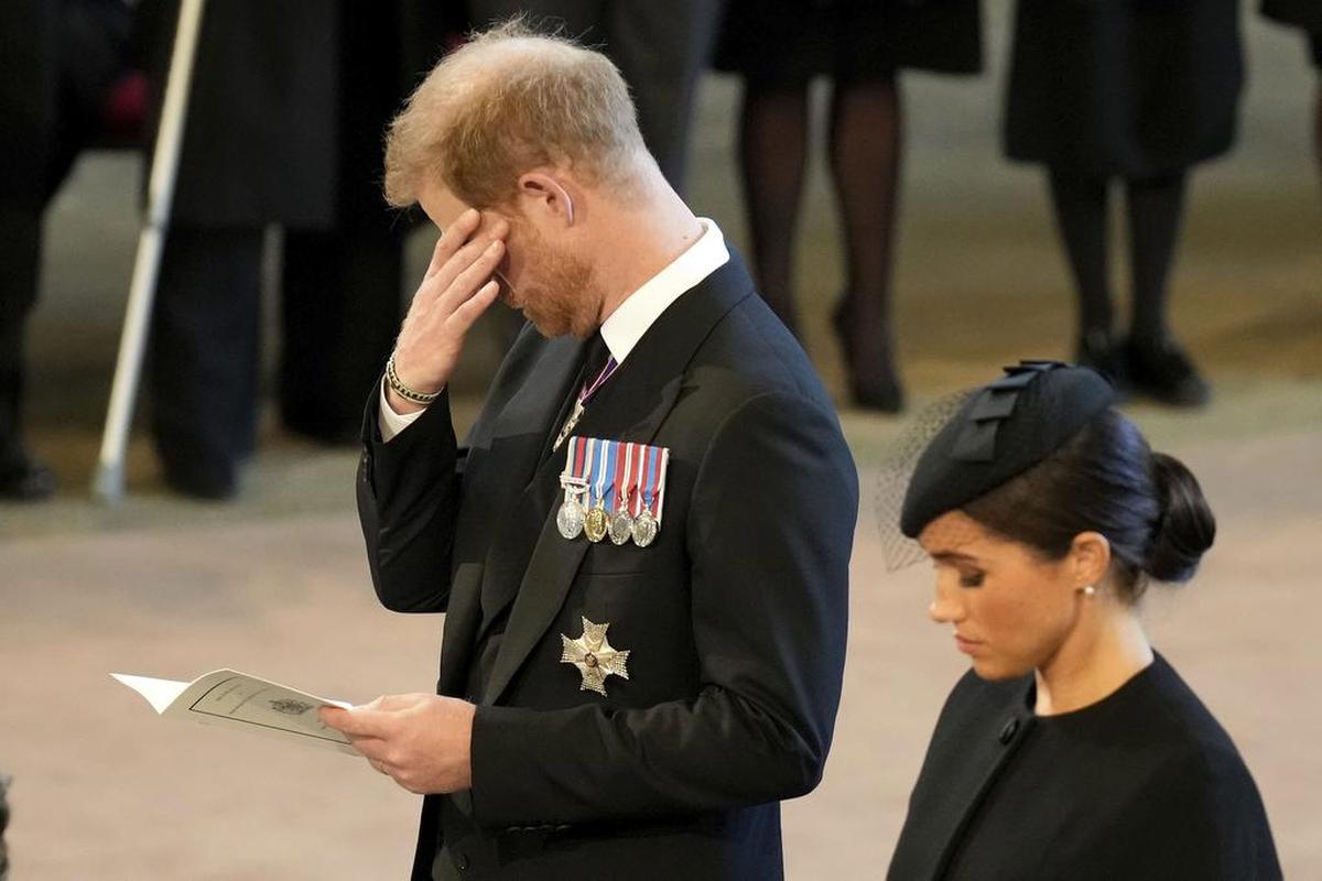 El príncipe Harry y su esposa Meghan, duquesa de Sussex, presentan sus respetos a la reina Isabel II mientras el ataúd descansa en Westminster Hall para su estado de reposo, en Londres, el miércoles 14 de septiembre de 2022. (Christopher Furlong/AP)