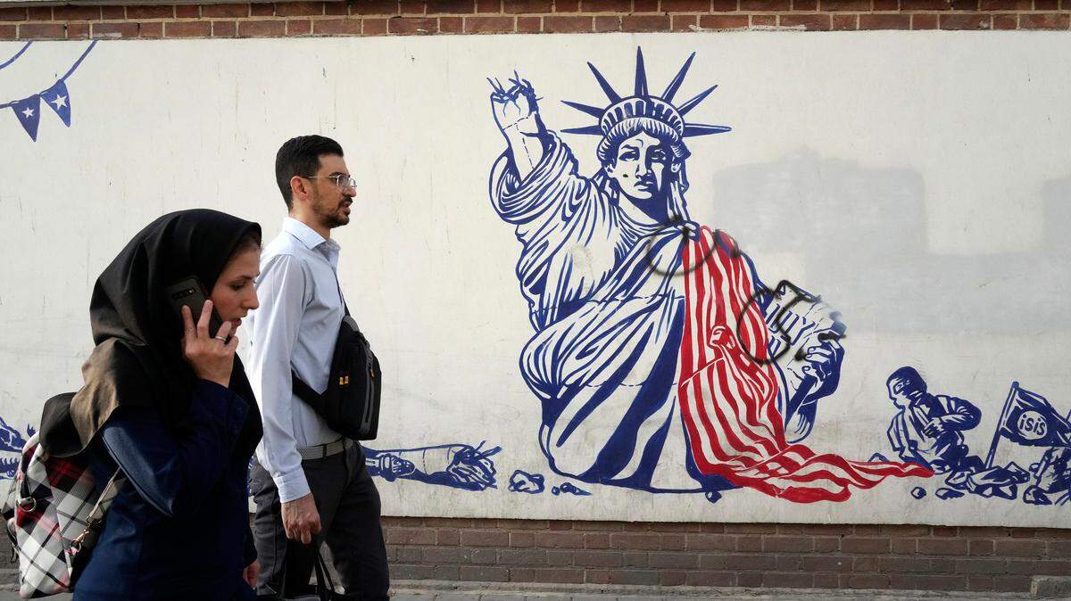 Foto de archivo. Dos personas caminan junto a un mural en la pared de la antigua embajada de Estados Unidos en Teherán, Irán, el 19 de agosto de 2023.