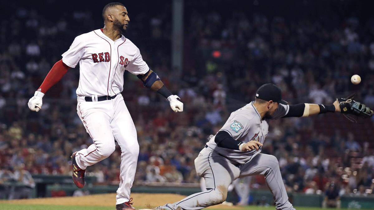 El tercera base de los Medias Rojas Eduardo Núñez llega quieto a la inicial luego de un mal tiro del torpedero de los Marlins J.T. Riddle, jugada que posibilitó que J.D. Martínez anotara la carrera del triunfo de Boston, el 28 de agosto de 2018.