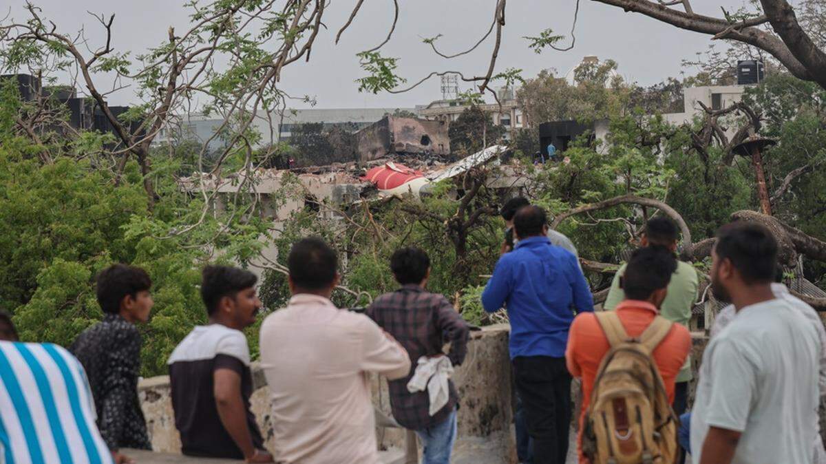 Personas observan los restos de un avión accidentado cerca del Aeropuerto Internacional Sardar Vallabhbhai Patel en Ahmedabad, Gujarat, oeste de la India, el 13 de junio de 2025. El vuelo AI171 de Air India, con destino a Londres y con 242 pasajeros y tripulantes a bordo de un Boeing 787-8, se estrelló minutos después del despegue en la zona de Meghaninagar, en Ahmedabad. (Londres) EFE/EPA/RAJAT GUPTA