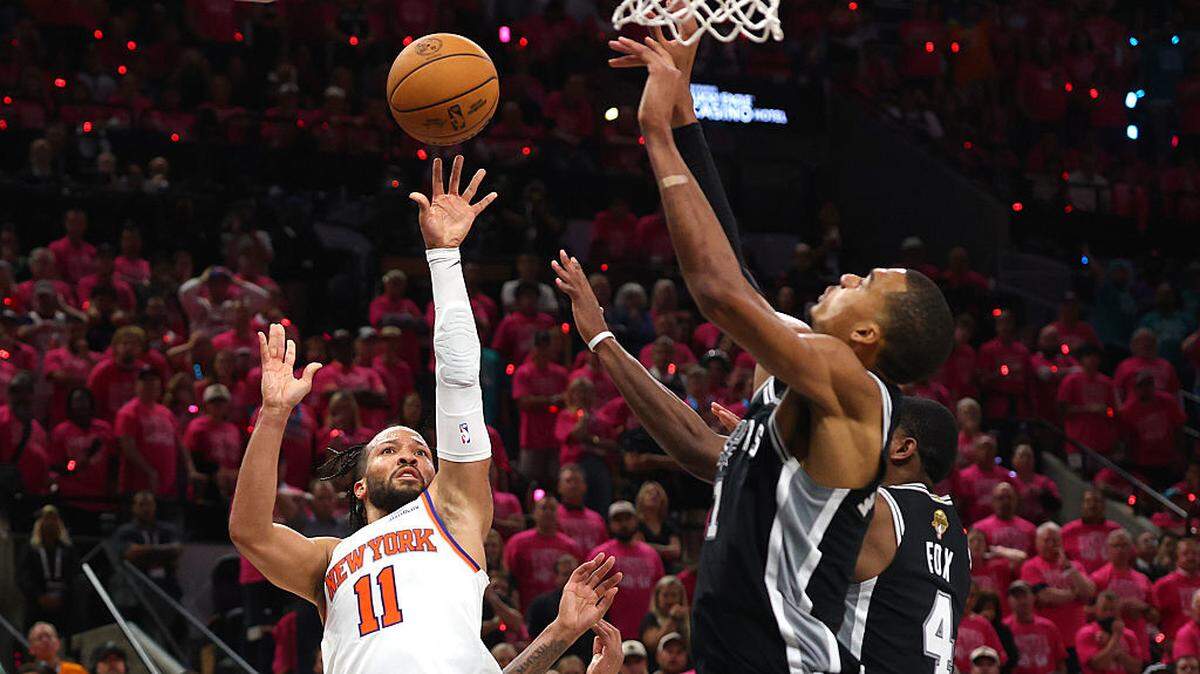 El astro de los Knicks de Nueva York Jalen Brunson tira al aro ante la marca de Victor Wembanyama (#1) y De'aaron Fox, de los Spurs, en el primer partido de las Finales de la NBA celebrado el 3 de junio de 2026 en San Antonio. 