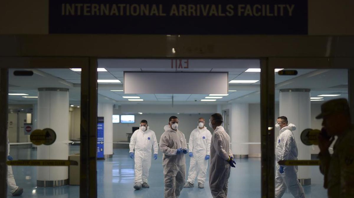 Members of the Puerto Rico National Guard that examine passengers that arrive in Puerto Rico to detect coronavirus walk through Luis Muñoz Marín International Airport, in Carolina, Puerto Rico, on Tuesday, March 17, 2020.
