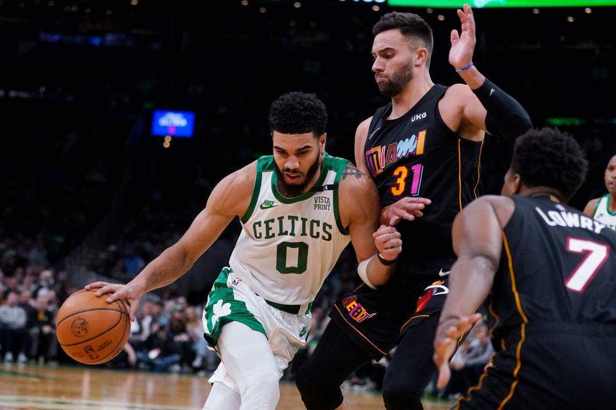 El jugador de los Celtics Jayson Tatum (izq. ) conduce la pelota ante la marca de Max Strus, del Heat de Miami, en el partido celebrado el 30 de marzo de 2022 en Boston.
