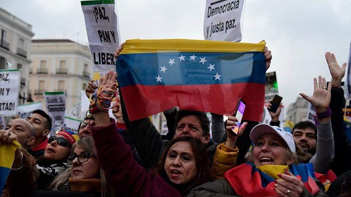 Venezuelans living in Spain hold signs reading "Democracy now!" and Venezuelan flags during a demonstration in support of the Venezuelan opposition in Madrid on January 25, 2020. (Photo by JAVIER SORIANO / AFP) (Photo by JAVIER SORIANO/AFP via Getty Images)
