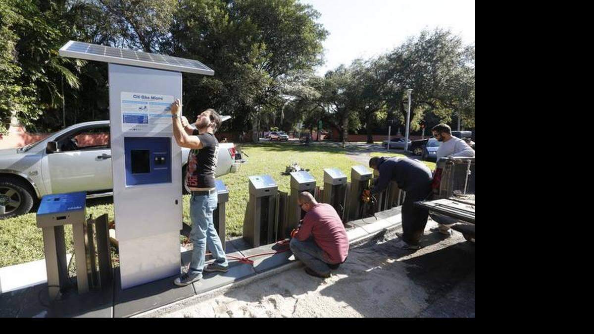 Trabajadores de la ciudad instalan el servicio de alquiler de bicicletas el jueves, 11 de diciembre de 2014.