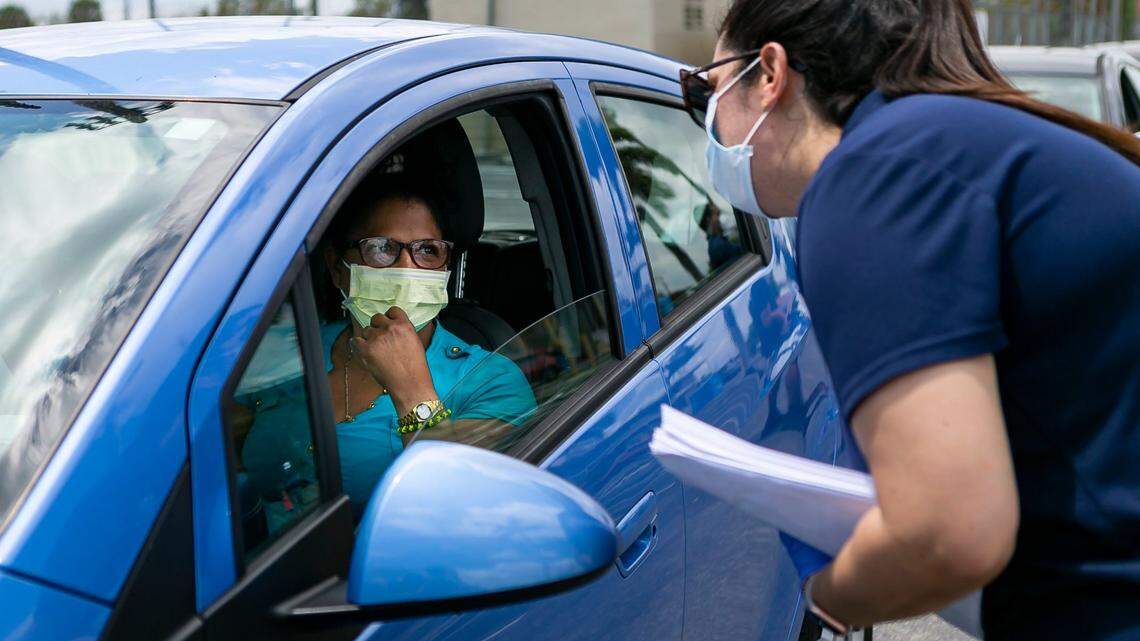 City of Hialeah employees distribute printed unemployment forms to Miami-Dade County residents outside the John F. Kennedy Library in Hialeah on April 7, 2020, shortly after the coronavirus pandemic began.