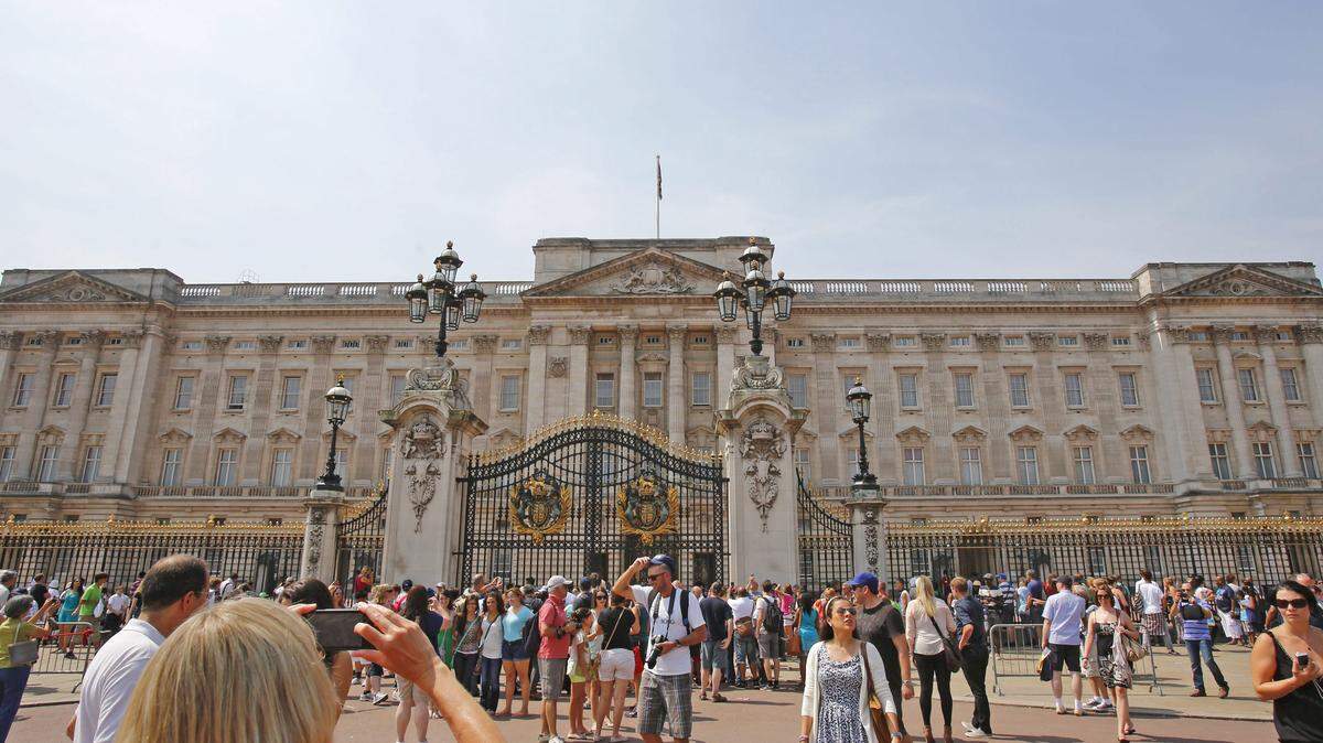 Un grupo de personas aguarda en la entrada del palacio de Buckingham, en Londres (Reino Unido) .