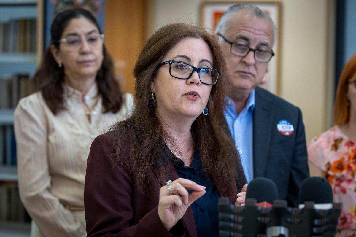 La directora de Bibliotecas de Hialeah, Grisel Torralbas, centro, responde preguntas de los periodistas en la Biblioteca John F. Kennedy de Hialeah tras el anuncio de la apertura de una Oficina de Pasaportes en ese sitio. Hialeah, Florida, 19 de marzo de 2024 -