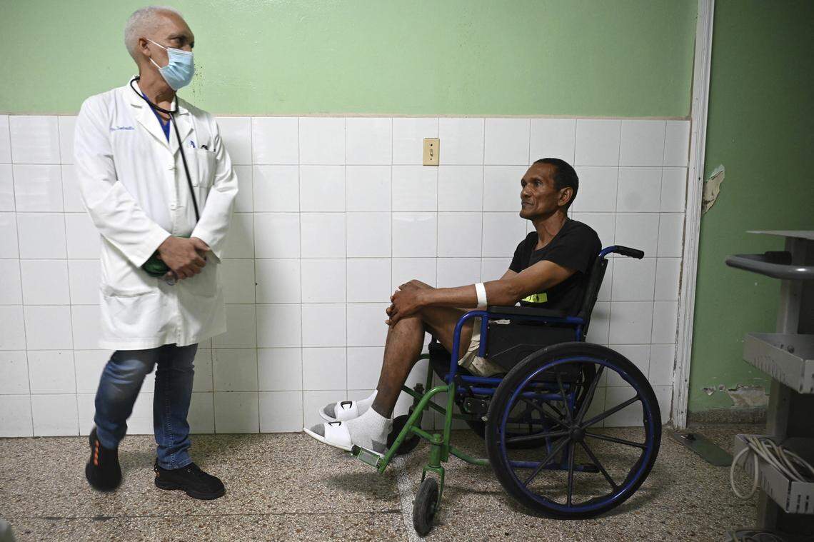 Doctor Alexey Lopez waits next to a patient before examining him in the cardiology room of the Calixto Garcia hospital in Havana on February 12, 2024. Cubans were already dealing with a total lack of medicines and hospitals in deplorable condition when US pressure tactics exacerbated the blackouts, which put the island on the brink of health collapse.