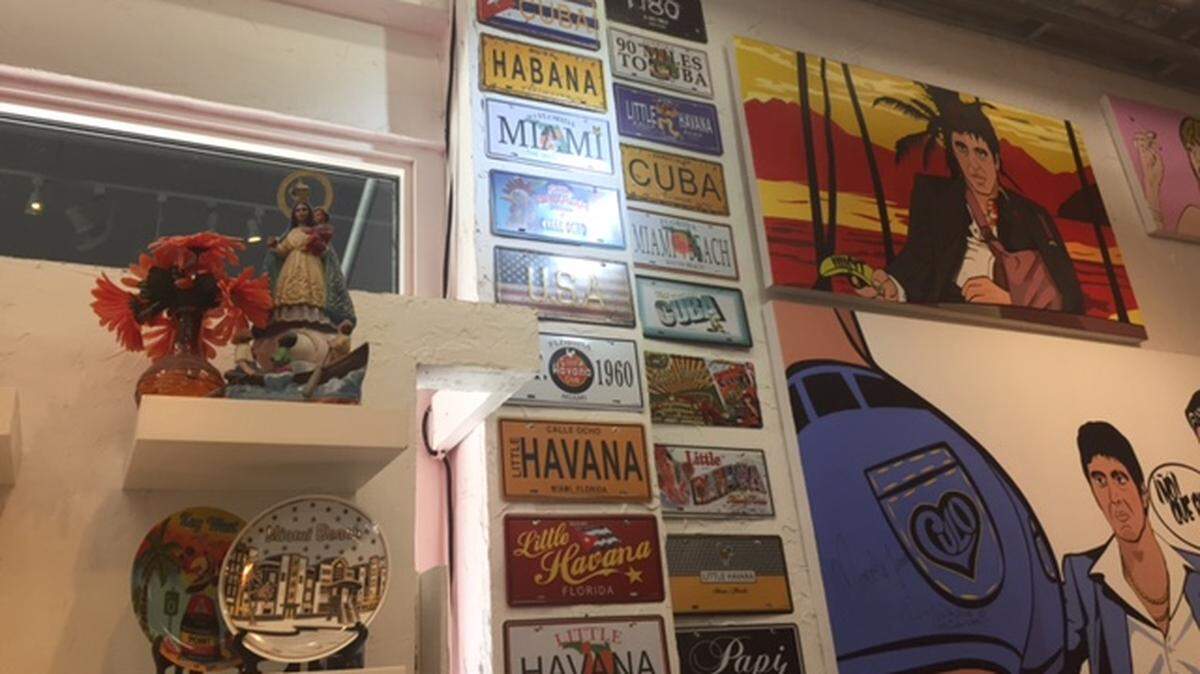 An image of the Virgin of Caridad del Cobre next to license plates and posters of Al Pacino as Tony Montana from ‘Scarface’ are what is for sale at this Little Havana shop.