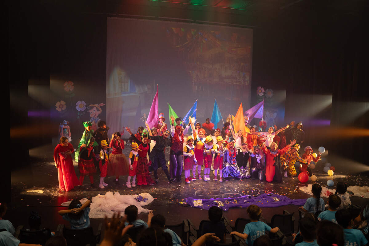 Actores, niños y niñas, familiares y público al finalizar la representación en el Sandrell Rivers Theater.