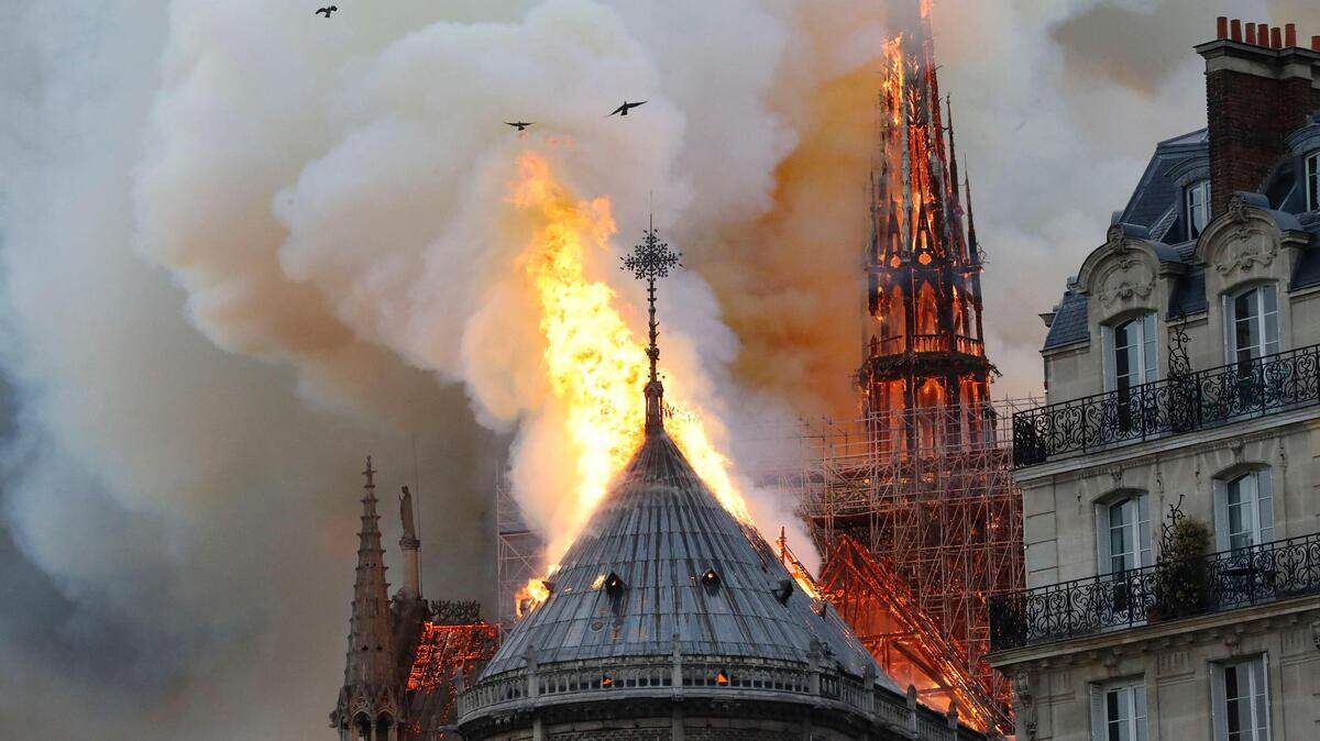 La aguja de la catedral de Notre-Dame en París consumida por las llamas.