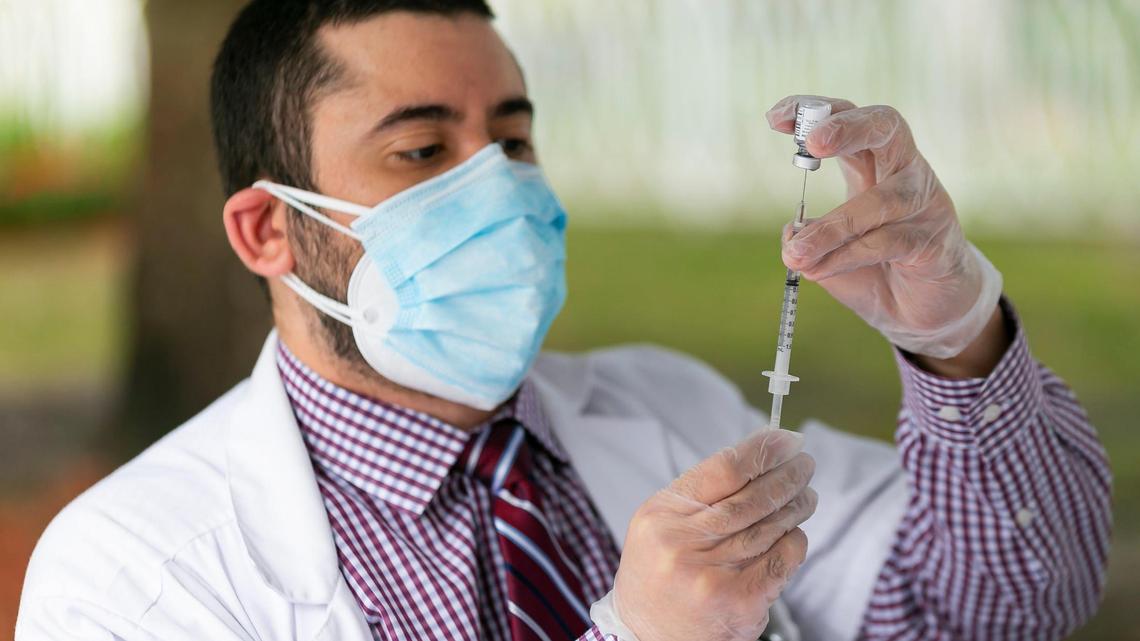 El Dr. Daniel Carvajal extrae una jeringa con la vacuna COVID-19 de Pfizer-BioNTech en The Palace Renaissance & Royale, un centro de vida asistida en Kendall, el miércoles 13 de enero de 2021.