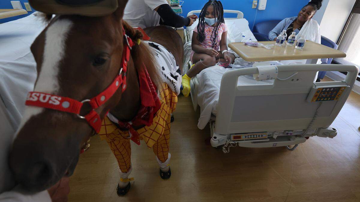 “Pegasus” vestido como el personaje de Toy Story “Woody” visita a una joven paciente mientras Alexandra Ramos comparte pegatinas especiales con ella después de una sesión de terapia emocional en el Hospital Infantil Holtz en Jackson Memorial el pasado 15 de agosto.