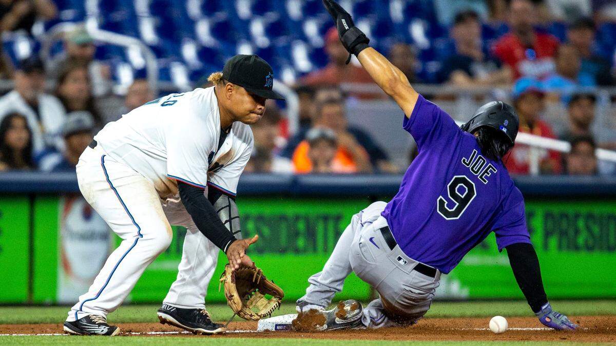 El tercera base de los Marlins Willians Astudillo pone out a Connor Joe, de los Rockies de Colorado, celebrado el 21 de junio de 2022 en Miami.