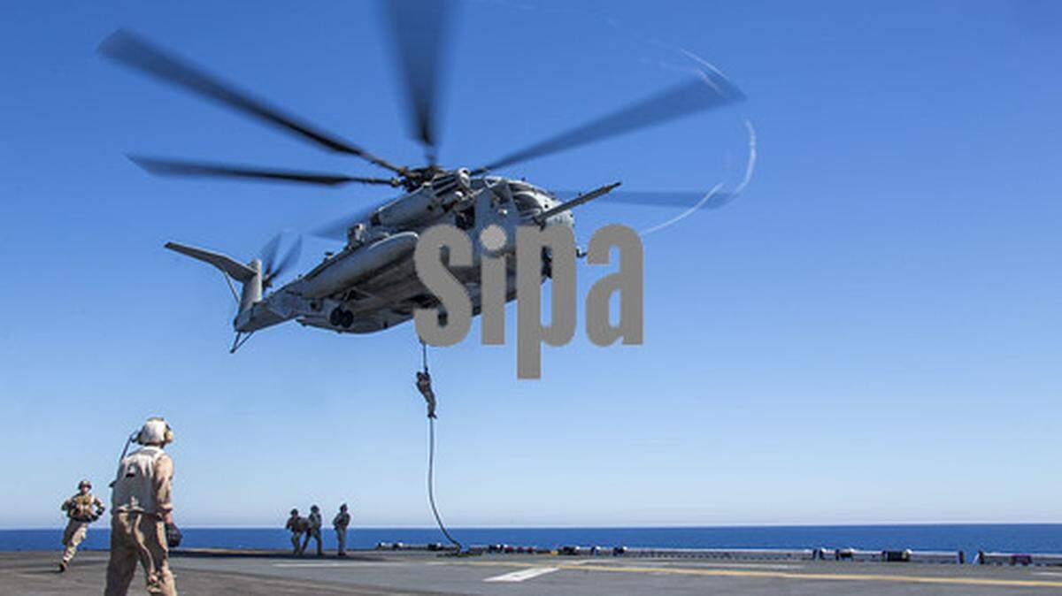 Nueva imagen publicada por usnavy en Flickr con el siguiente título: Marines saltan por cuerda rápida desde un helicóptero CH-53E Super Stallion hacia el USS Bataan (LHD 5).