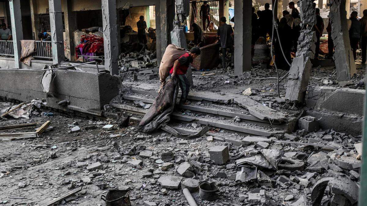  Palestinos inspeccionan una escuela dañada tras un ataque aéreo israelí en el campo de refugiados de Jabalia, en el norte de la Franja de Gaza, el 12 de mayo de 2025. 