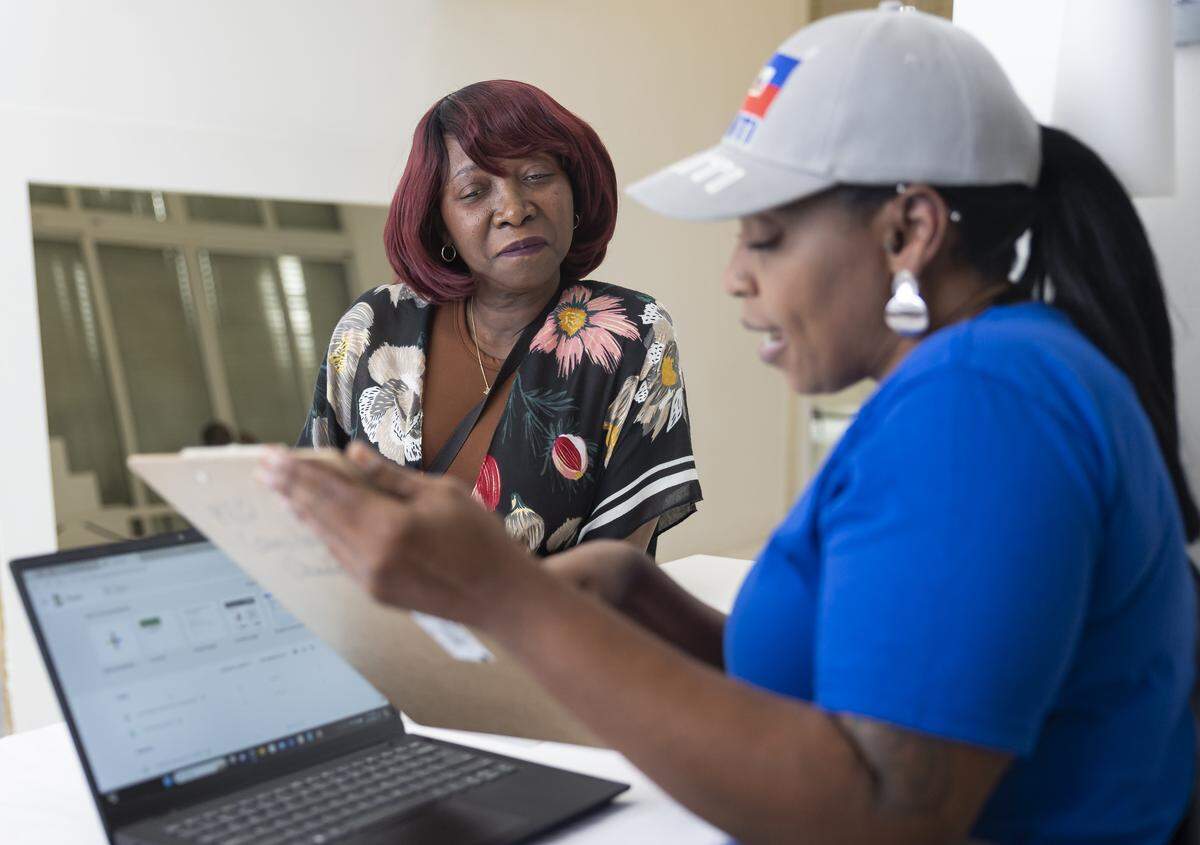 Enise Joseph, left, is registered for a community resource fair by Claudya Gebara, a volunteer at Jobs For Us, at the Magic City Innovation District on Friday, May 31, 2024, in Miami, Fla. Hialeah, Wynwood and Doral will host several job fairs in September and Octobers.