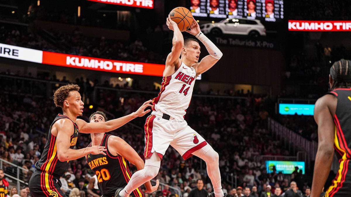 El escolta del Heat Tyler Herro (14) trata de pasar la pelota ante la defensa de los Hawks, en el partido del play-in de la NBA celebrado el 18 de abril de 2025 en Atlanta.