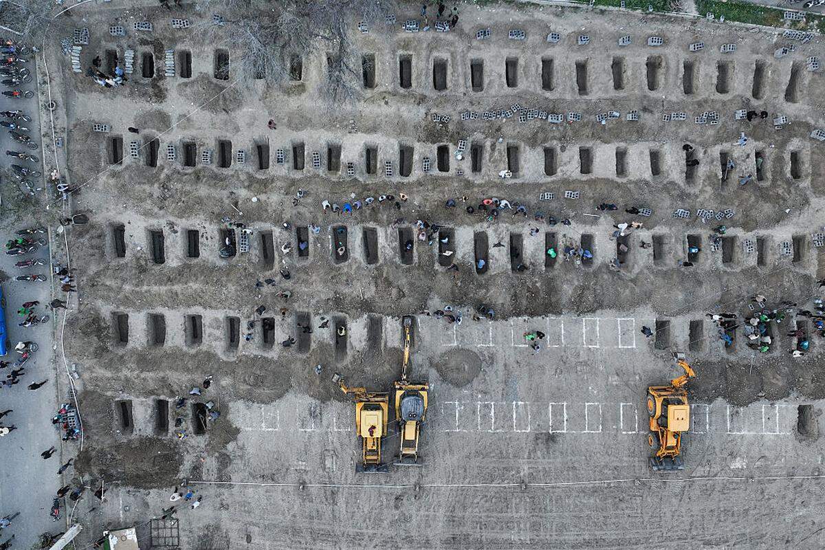 En esta fotografía aérea difundida por el Centro de Prensa de Irán, los dolientes cavan tumbas durante el funeral de las niñas muertas en un supuesto ataque a una escuela primaria en la provincia iraní de Hormozgan, en Minab, el 3 de marzo de 2026.