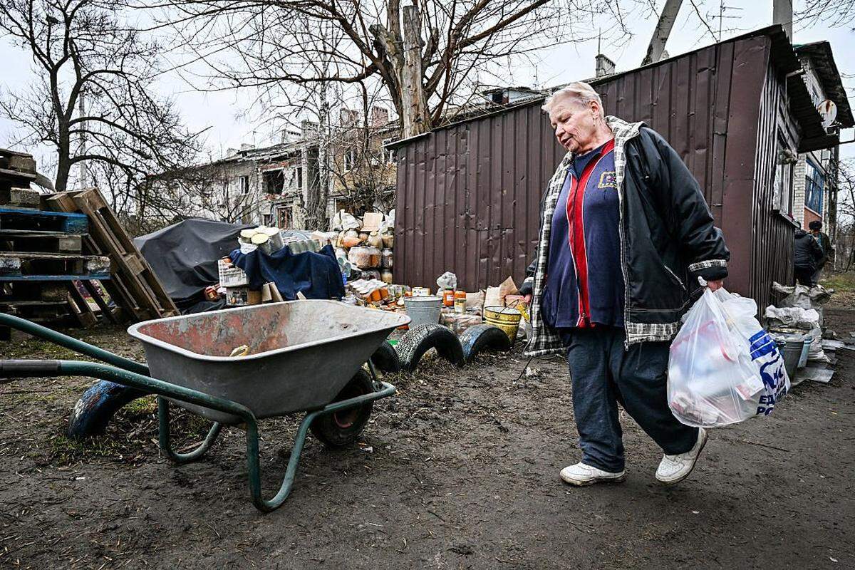 Una mujer carga una bolsa de ayuda humanitaria distribuida por voluntarios locales en Donetsk, una zona de Ucrania bajo control ruso, el 27 de marzo de 2026, en medio del conflicto ruso-ucraniano en curso.