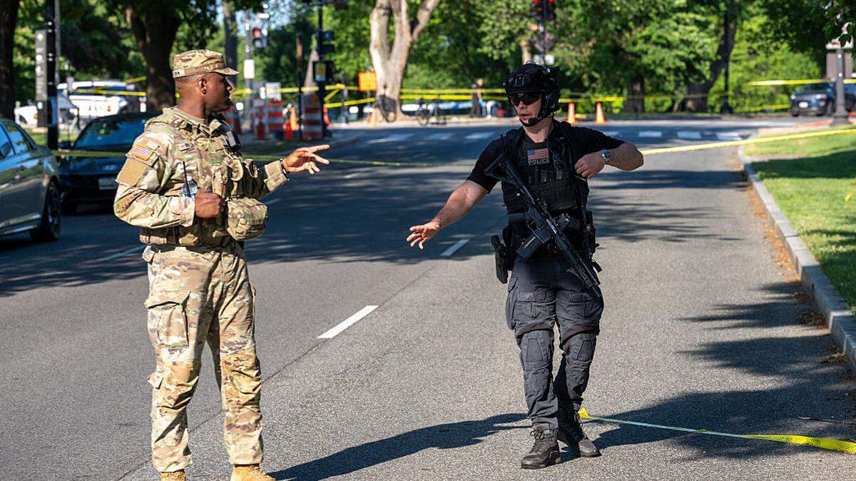 Un soldado de la Guardia Nacional y un agente del Servicio Secreto de EEUU vigilan la escena del crimen tras un intercambio de disparos entre el Servicio Secreto y un atacante en el National Mall, el lunes 4 de mayo de 2026, en Washington, DC. La policía informa que un atacante disparó contra un agente del Servicio Secreto e hirió a un transeúnte antes de ser abatido por la policía.