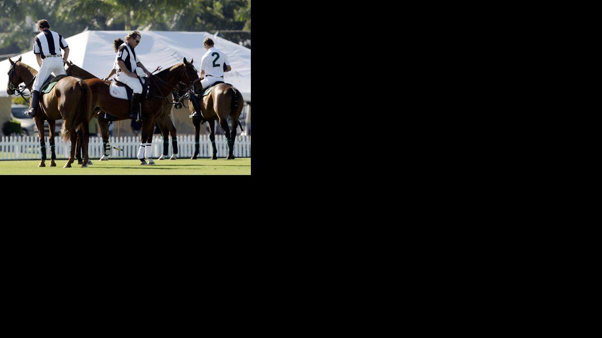 VARIOS ARBITROS guardan silencio en memoria de los caballos muertos, durante el Abierto de Polo en 
Wellington.