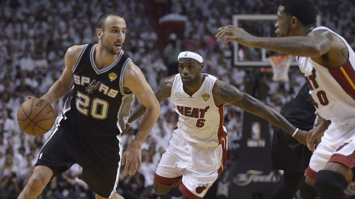 Manu Ginóbili (izq.) trata de pasar la defensa de LeBron James (centro) y Udonis Haslem en un partido de la Final de la NBA entre los Spurs y el Heat, el 9 de junio de 2013 en Miami.