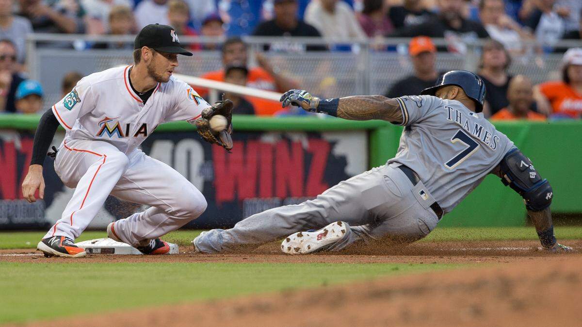 El torpedero de los Marlins JT Riddle (izq.) pone out en tercera base al corredor de los Cerveceros Eric Thames, en el tercer inning del partido celebrado el 9 de julio de 2018 en Miami.